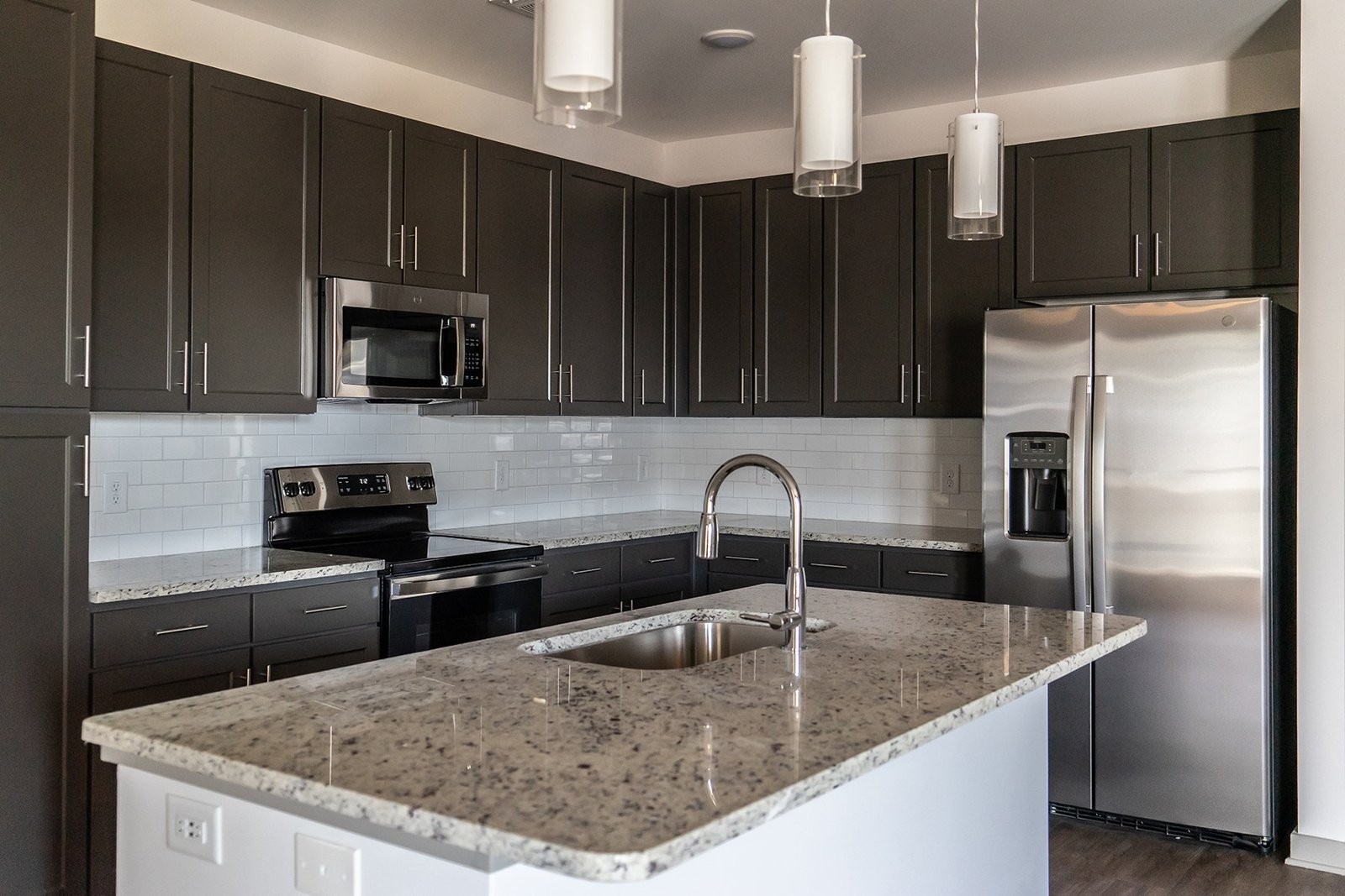 Apartment kitchen with dark cabinetry and an island